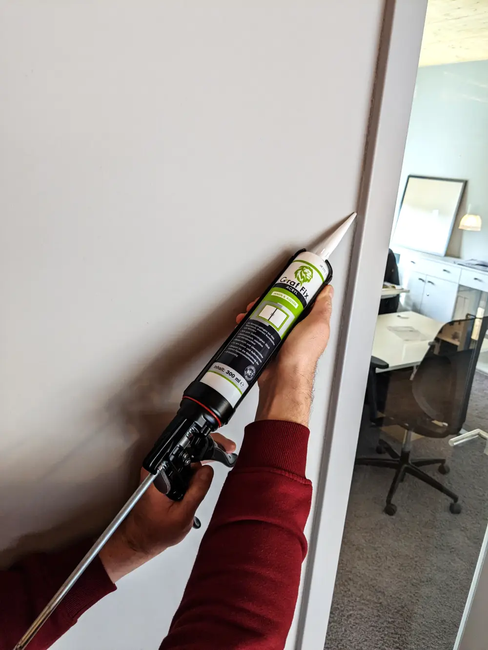 Person benutzt den Graf Fix Acryl an einem Tührrahmen