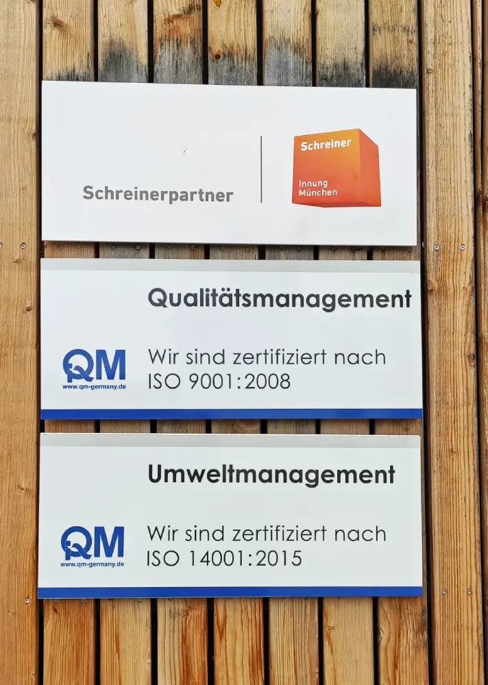 Schreinerpartner, Qualitätsmanagement und Umweltmanagement Schilder hängen an einer Holzwand