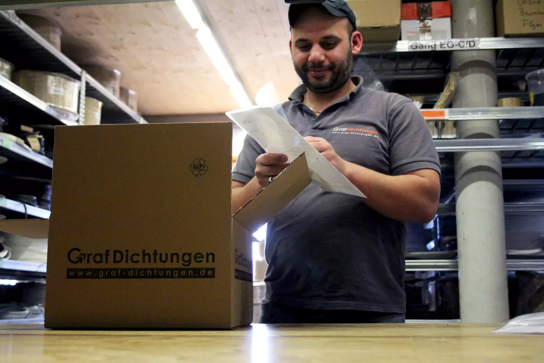 Mitarbeiter packt im Lager Pakete Mitarbeiter packt im Lager Pakete