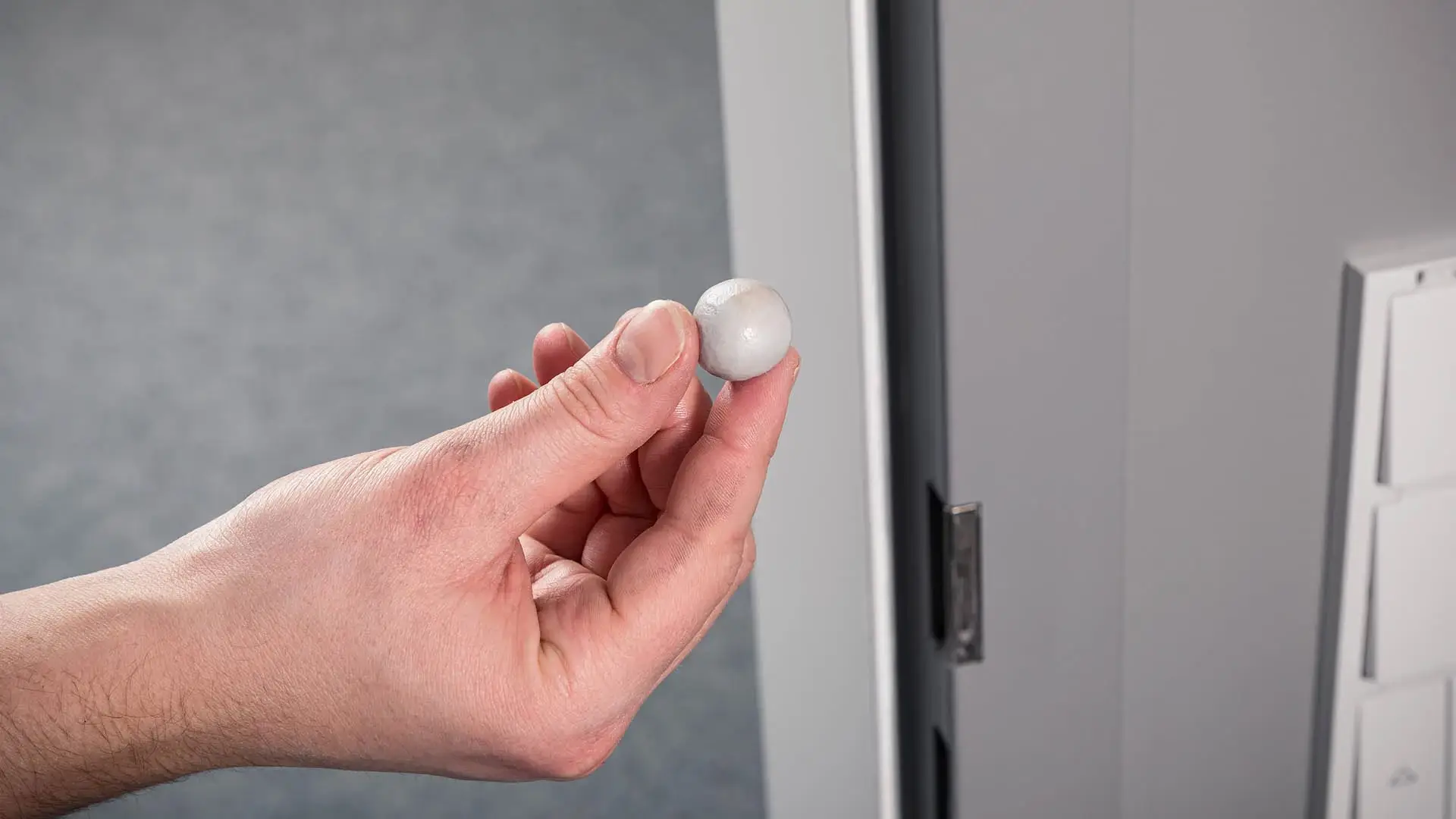 Dichtungsgröße bestimmen mit einer Knetkugel Person hält eine Knetkugel zur Abmessung einer Dichtungspresse