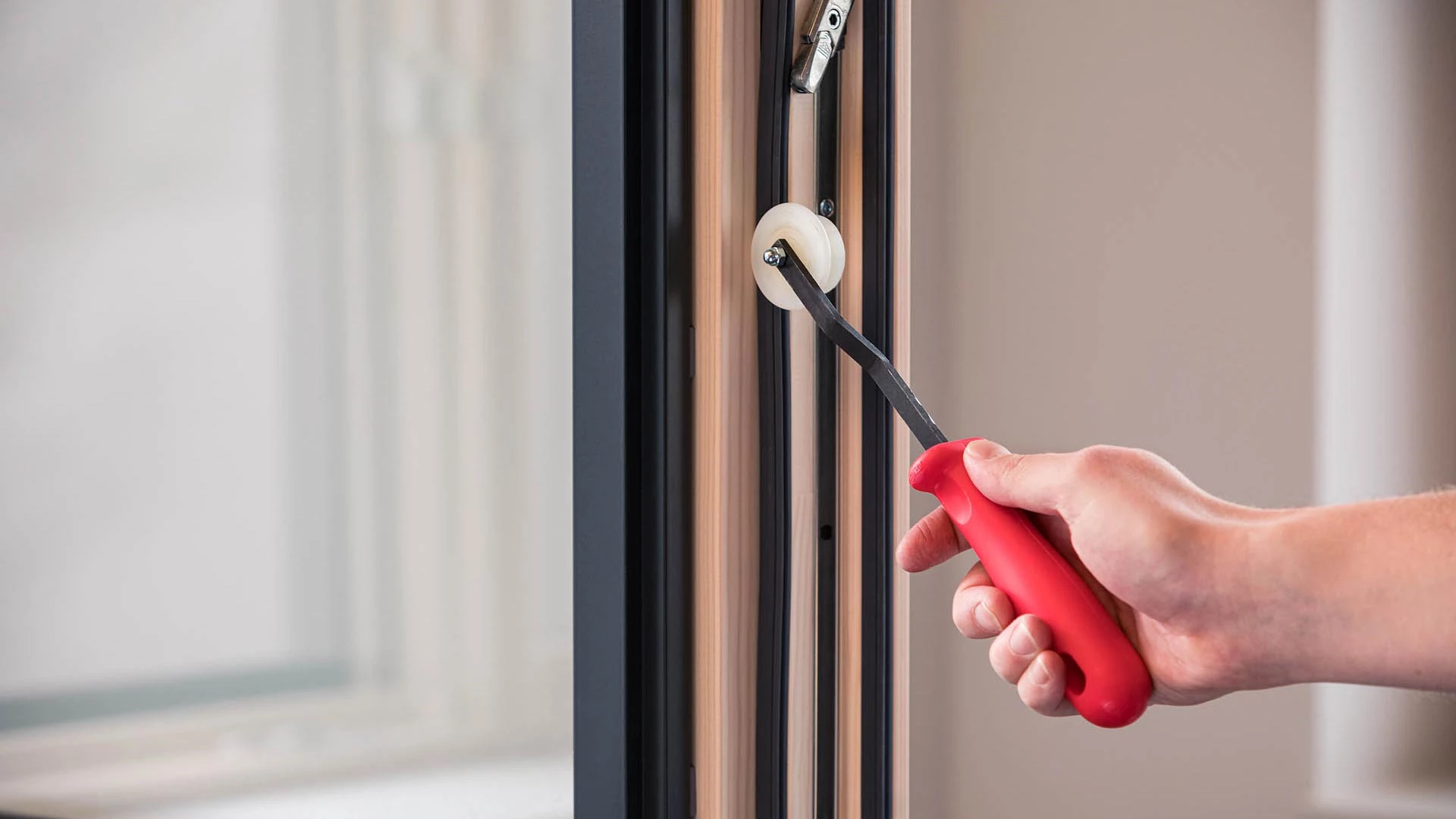 Dichtung wird mit Einroller in Fenster gedrückt Dichtung wird mit Einroller in Fenster gedrückt