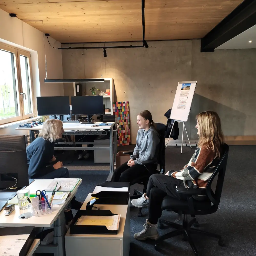 Girlsday Foto von einer Mitarbeiterin die zwei Mädchen die Buchführung näher bringt